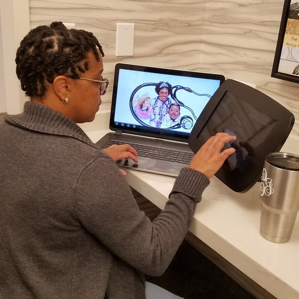 A woman sitting at a desk using her laptop.