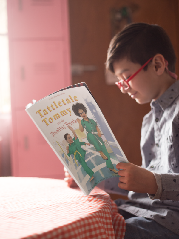 A boy is reading a book on the table