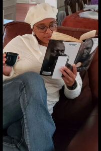 A woman reading a book and holding a cup of coffee